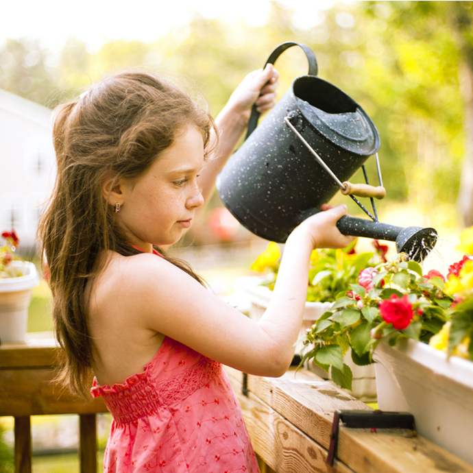Girl-watering-flowers a young girl watering flowers