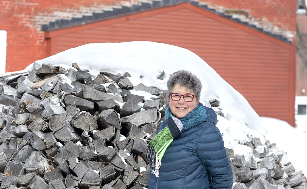 Woman standing by wood pile