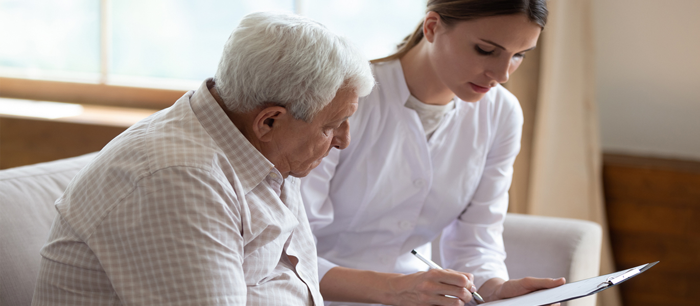 patient-provider-general page size.jpg Provider talking with a patient over paperwork