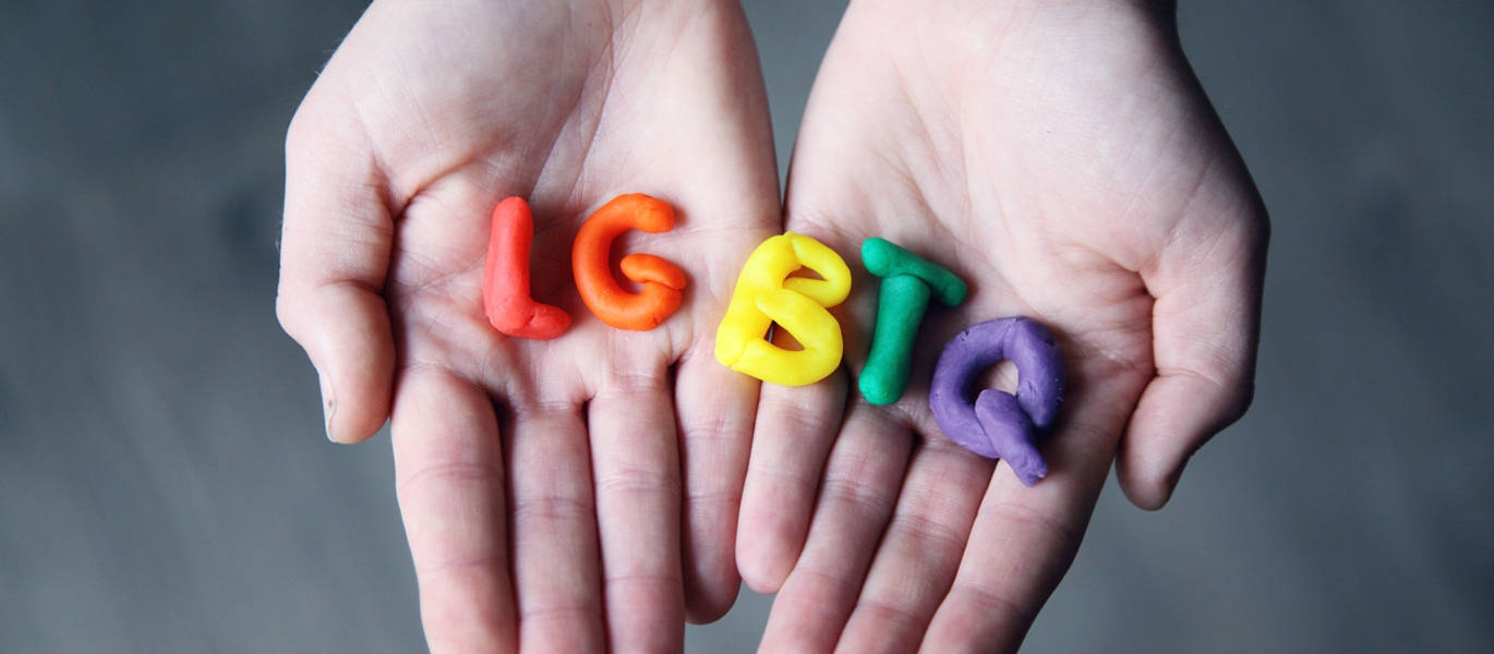 Person hold LGBTQ letters