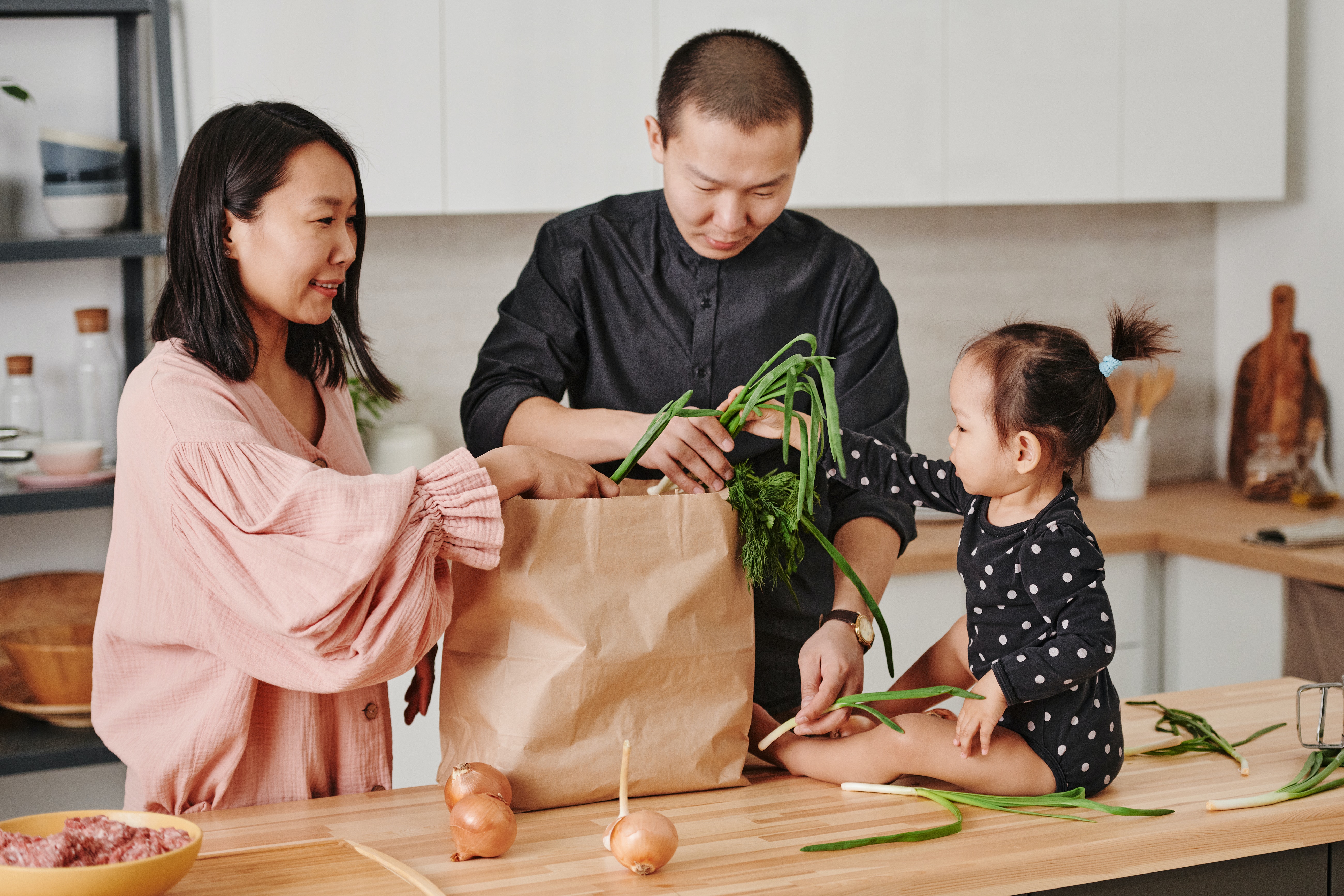 Family in kitchen unpacking groceries