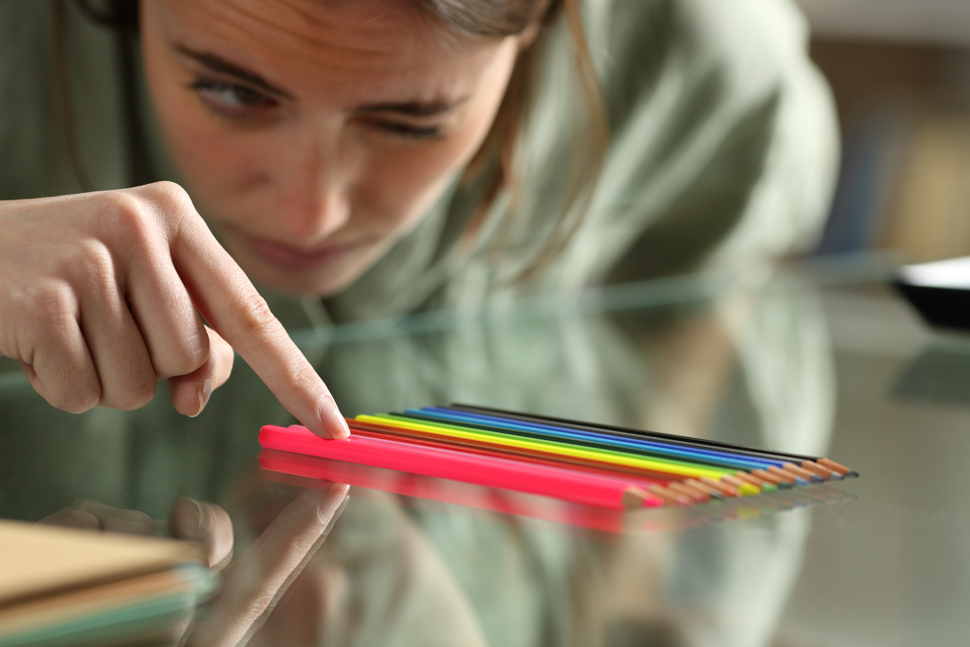 Person aligning up pencils on a table