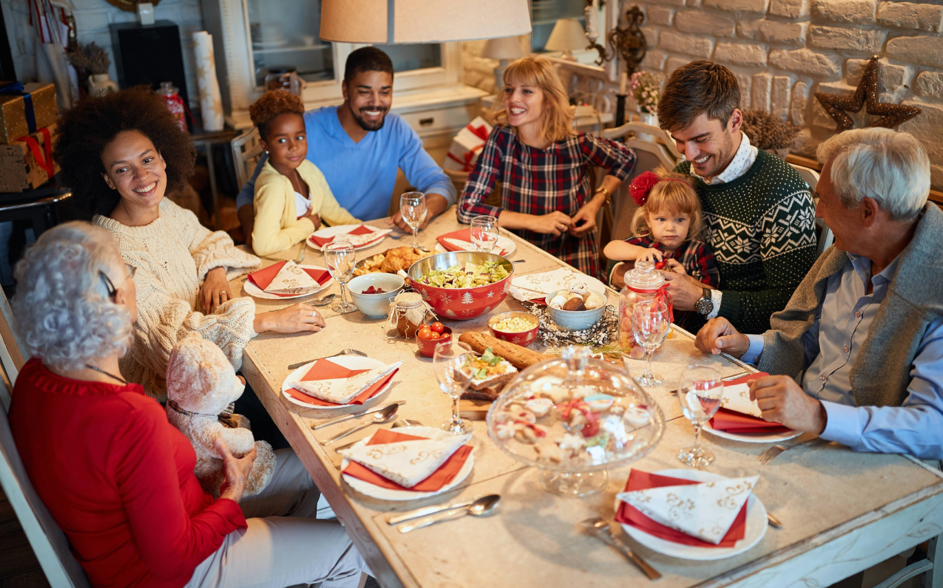 family and friends sitting at a table for a holiday dinner