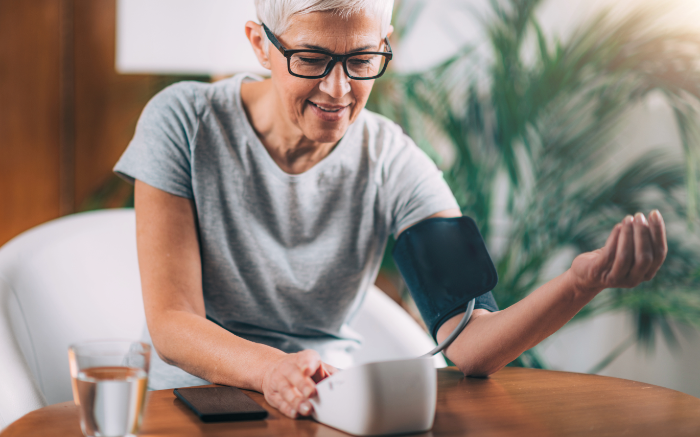 Senior testing blood pressure with a cuff