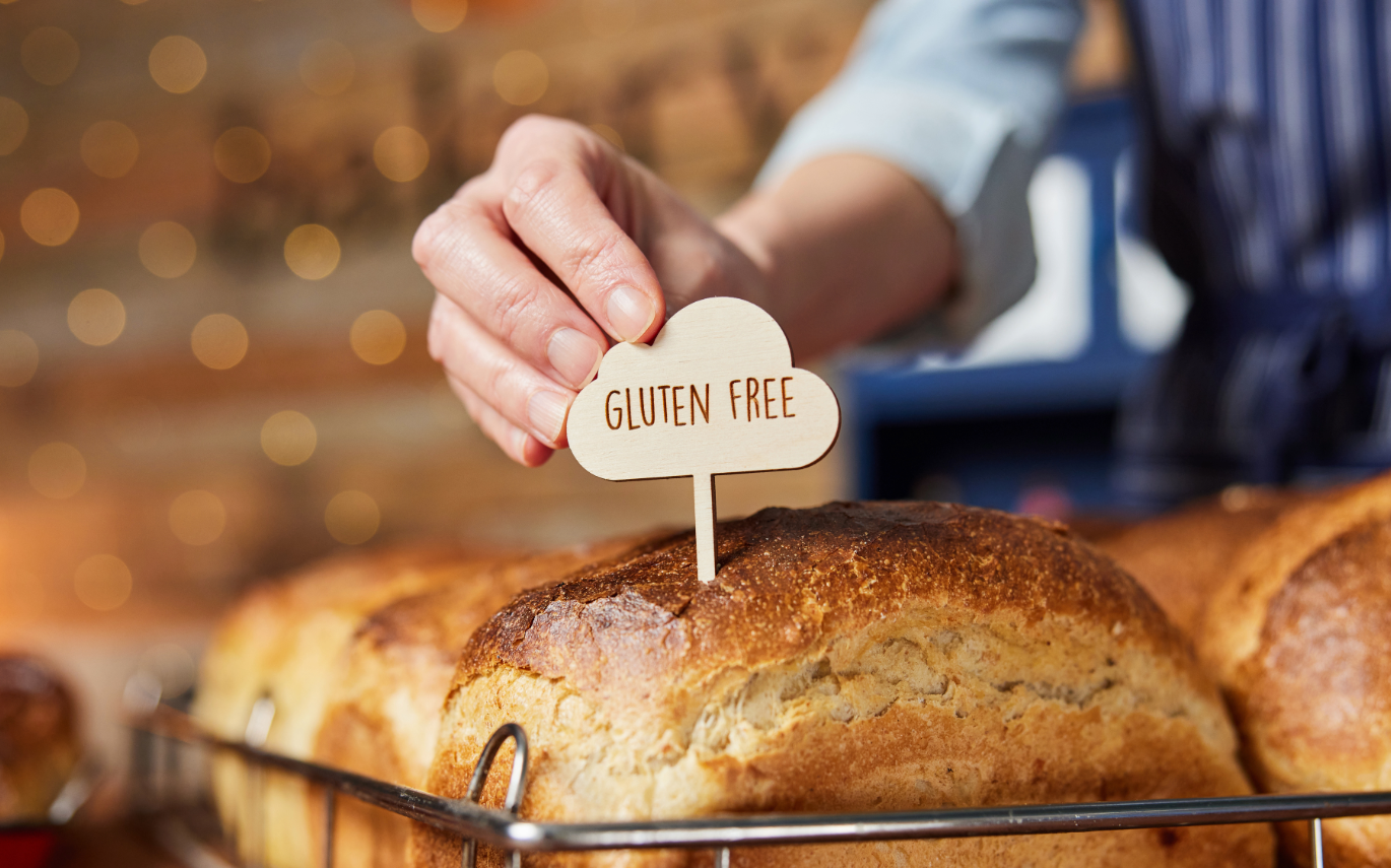 Baker placing a "Gluten-Free" sign on bread