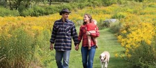 Couple and baby walking in a field