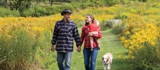 Couple and baby walking in a field