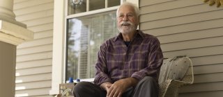 Elderly man sitting on his porch