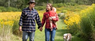 A family and their dog walking in a field