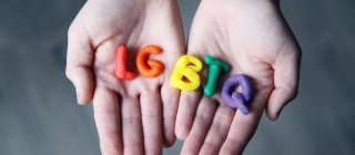 Person hold LGBTQ letters
