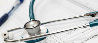 Stethoscope laying on paper forms