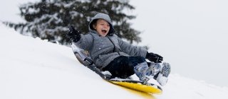 Child sledding down Vermont hill