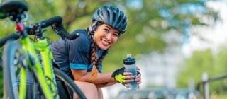 Woman taking a break to drink water after biking