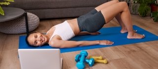 Woman doing bridge exercise while watching video