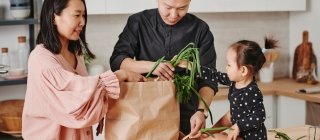 Family in kitchen unpacking groceries