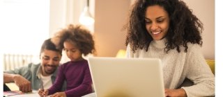 Family in their home with mom on a computer