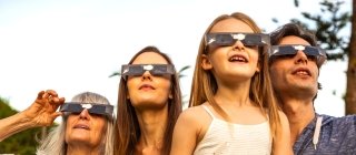 Family wearing eclipse glasses