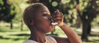 woman taking an inhaler outside