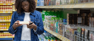 woman looking at labels while grocery shopping