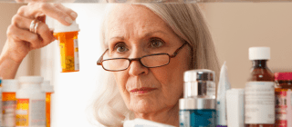 woman looking at prescriptions in medicine cabinet