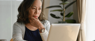 woman looking at computer contemplatively