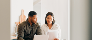 couple looking at a computer and papers 