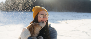 woman holding a dog outside in winter