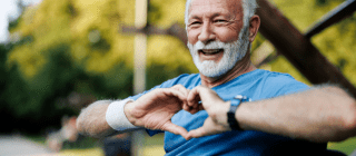 man sitting on a bench making a heart symbol with his hands