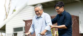 man acting as a caregiver to another man with a walker
