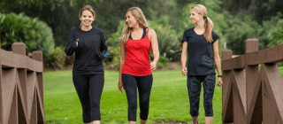 three women walking across a bridge