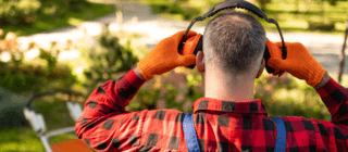 man putting on hearing protection before mowing lawn