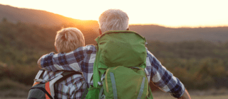 senior couple watching the sunrise over the mountains