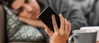 woman laying down holding a phone 