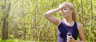 woman overheating after a walk while holding a water bottle