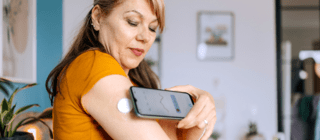 woman checking her blood sugar using an app