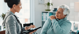 Woman speaking with a chiropractor about shoulder pain