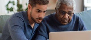 man helping his father use the computer 