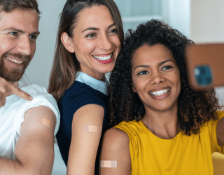 three adult friends taking a selfie together after getting vaccinated