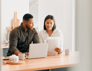 couple looking at a computer and papers 