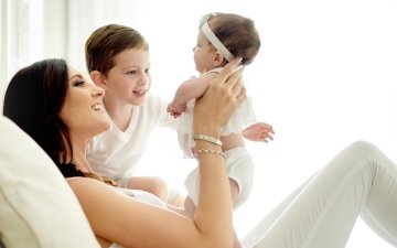 A mother with newborn and younger child