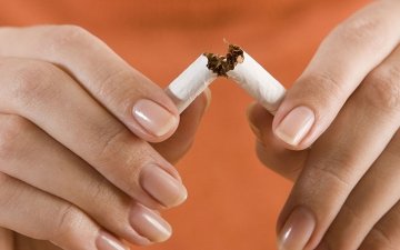 A person breaking a cigarette in half for quitting smoking