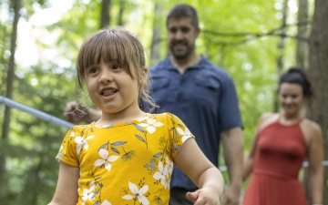 Girl playing in the woods with her parents