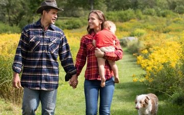 A family and their dog walking in a field