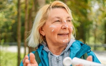 Woman applying sunscreen during a hike