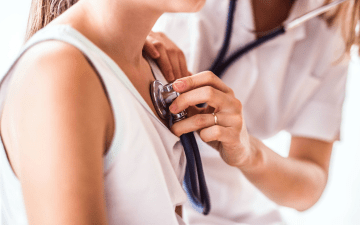 Doctor using Stethoscope on young patient