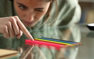 Person aligning up pencils on a table