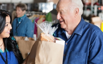 Man picking up food from food shelf