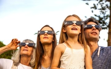 Family wearing eclipse glasses