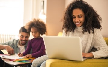 Mother working from home while dad and daughter having fun laptop computer work family