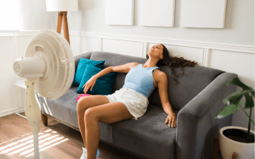 Woman using a fan to cool down